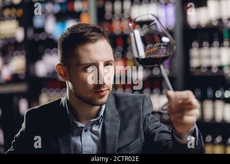 Sommeliers male hold glass red wine tasting degustation card Stock Photo