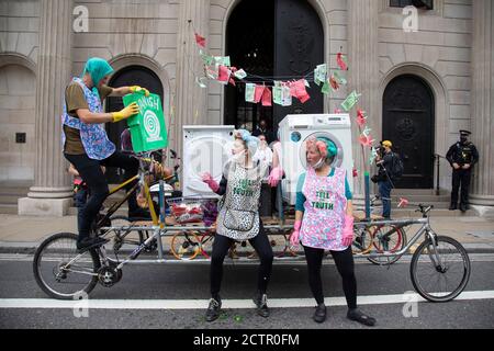 Extinction Rebellion ‘Dirty Scrubbers’ old fashioned washer women in curlers wash and launder their ‘dirty money’ and greenwash stains outside the Bank of England in the City of London financial district in a performance designed to highlight the corruption of big business and banking on 9th September 2020 in London, United Kingdom. The activists shouted out for people to come from the banks and to bring their dirty money to be cleaned in their washing machines. Extinction Rebellion is a climate change group started in 2018 and has gained a huge following of people committed to peaceful protes Stock Photo