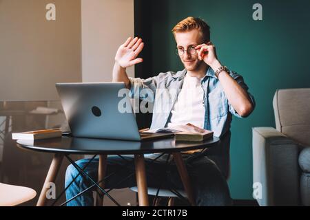 Young man college student in glasses studying distantly at home using video call Stock Photo