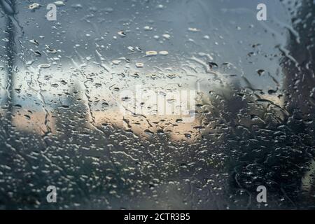 Background of water droplets on the windshield on a rainy evening with sun patterns Stock Photo