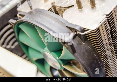 Dust on green CPU cooler PC computer with motherboard and computer case fragment close up Stock Photo