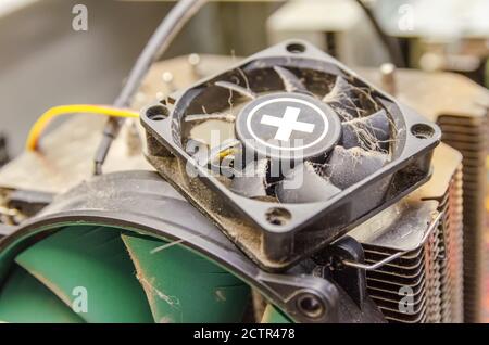 Dust, dirt on the CPU cooler of the computer with a fragment of the computer case close-up Stock Photo