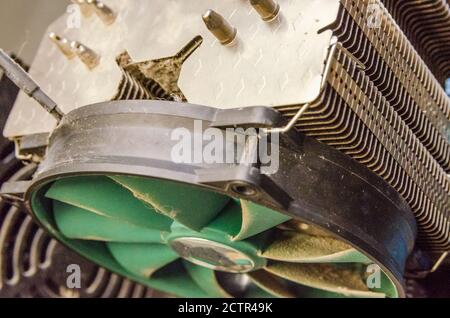 Dust on green CPU cooler PC computer with motherboard and computer case fragment close up Stock Photo