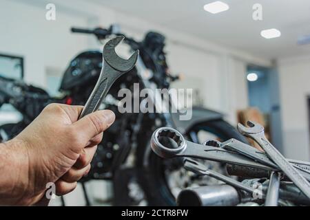 Hands of mechanic holding a wrench in workshop, professional tools, selective focus. Stock Photo
