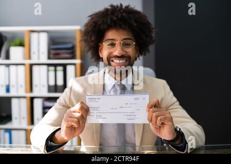 Holding Paycheck Or Payroll Check. Insurance Cheque In Hand Stock Photo