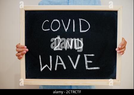 Covid 2nd wave. Coronavirus concept. Boy hold inscription on the board.