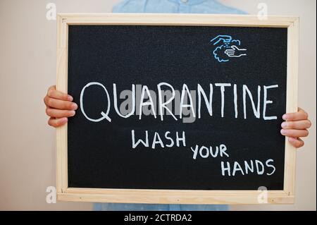 Quarantine wash your hands. Coronavirus concept. Boy hold inscription on the board. Stock Photo