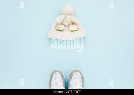 White women winter the boots and hat, glasses isolated on blue background. Flat lay, top view trendy fashion feminine background. Beauty blog concept. Stock Photo