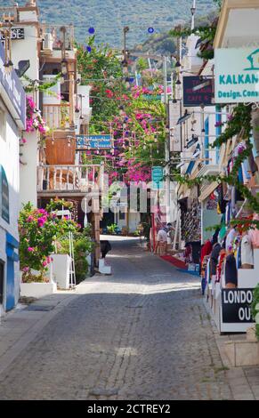 A narrow cobbled street in Kalkan, Turkey, with overhanging balconies covered in Bougainvillea. Kalkan is a popular holiday destination and is located Stock Photo