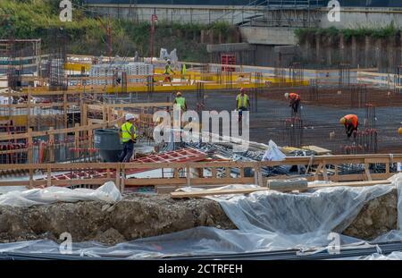 Milan italy september 8 2020: construction workers preparing the base with metal cages to be filled with concrete casting Stock Photo