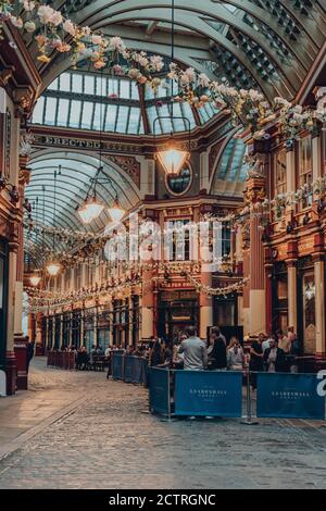London, UK - August 24th, 2020: People socially distanced drinking outside the Lamb Tavern pub located inside Leadenhall Market, a popular market in L Stock Photo