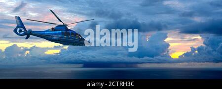 Dramatic: Modern Helicopter in Front of a spectacular sunrise Over the Atlantic Ocean Stock Photo