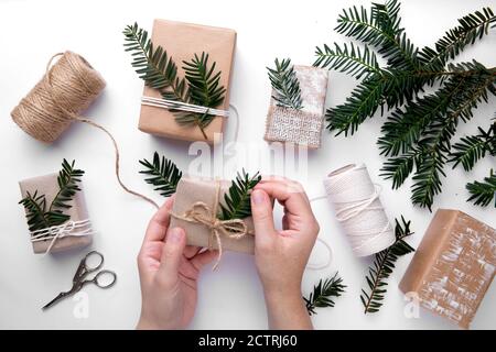 Gift decorating by hands for Christmas on white background Stock Photo