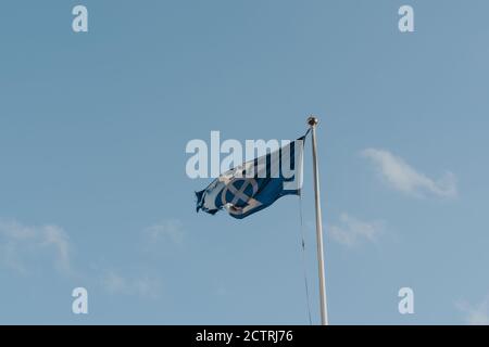 London, UK - August 25, 2020: Bridge Mark flag, symbol of the Bridge House Estates, on Tower Bridge, London, against blue sky. Stock Photo
