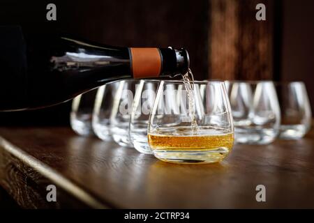 Waiter pouring wine into wineglass. Sommelier pours alcoholic drink. Stock Photo