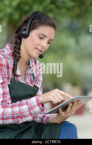 young florist selecting flowers from a tablet Stock Photo