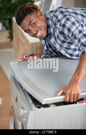 close-up of professional handyman repairing washing machine Stock Photo