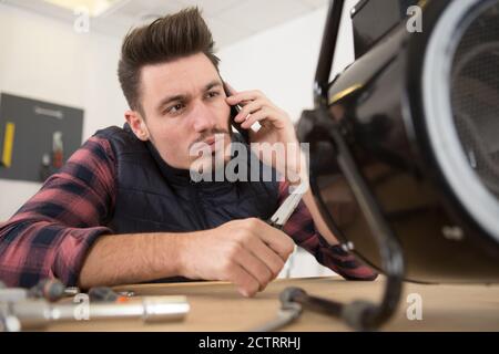 young technician working on broken computer in his office Stock Photo