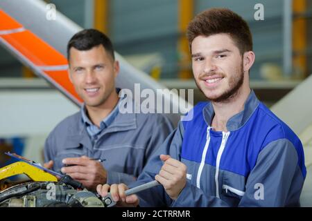 two flight engineers working in aircraft hangar Stock Photo
