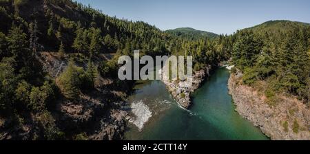 High aerial panorama view of mountain fork river stream where two rivers join together in Northern California on Smith River small ripples rocks trees Stock Photo