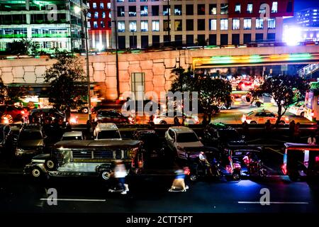 Bright city night lights and blurry transportation and pedestrians during rush hour Stock Photo