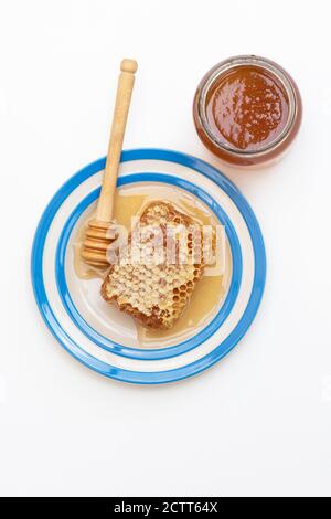 Honeycomb on a cornishware plate with a drizzler Stock Photo