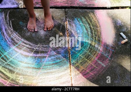 Low section of girl (6-7) standing on chalk drawing on pavement Stock Photo