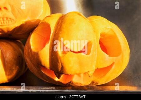 A scary face carved on a pumpkin for the holiday of Halloween. The traditional Jack lantern made of pumpkin is a symbol of Halloween. The mystical sym Stock Photo