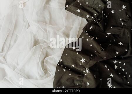 festive texture of the fabric is gray tulle and black synthetic with a star pattern Stock Photo