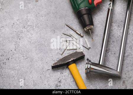 Hammer, drill and towel holder on a table with copy space, top view. The concept of installing a heated towel rail in the bathroom Stock Photo