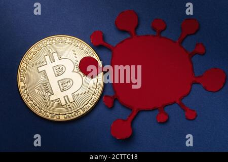 Bitcoin and paper virus model, top view. Concept of the impact of the coronavirus COVID-19 on cryptocurrency Stock Photo