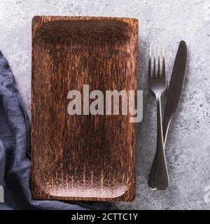 Empty wooden tray, napkin and cutlery on the table, top view Stock Photo