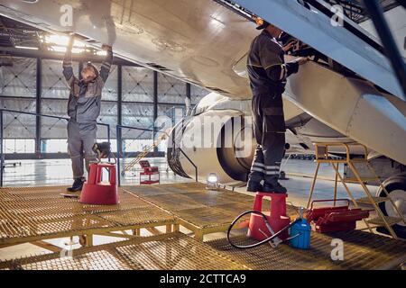 Engineer working on aircraft wing in aircraft maintenance factory Stock Photo