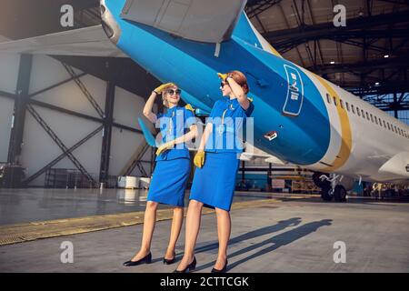 Happy smiling air hostess having fun in the outdoors after long flight Stock Photo