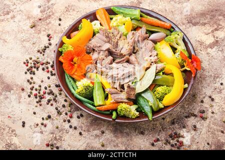 Appetizing beef stew with seasonal vegetables.Sliced pieces of baked beef laid and vegetables Stock Photo