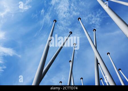 lots of empty flagpoles against a blue sky Stock Photo