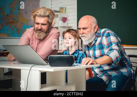 Happy grandfather father and son working with laptop. Happy man family using notebook together. Son teaching fathers and mature senior dad to use Stock Photo