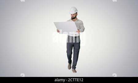 Confident young architect in white shirt and hardhat looking at Stock Photo