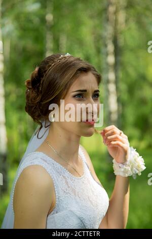 Portrait of a beautiful young bride. Wedding ceremony in classic style. Green background. Stock Photo