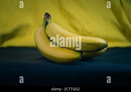 Bunch of bananas on a black and yellow background Stock Photo