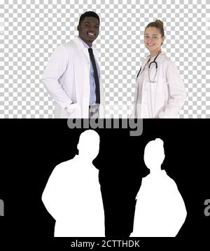 Two caucasian and afro american smiling doctors standing looking Stock Photo