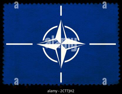 NATO (NORTH ATLANTIC  TREATY ORGANIZATION ) flag on the old grunge postage stamp isolated on black background Stock Photo