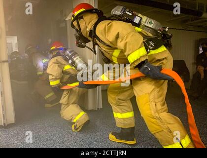 Sailors assigned to USS Gerald R. Ford's (CVN 78) damage control repair locker five, demonstrate fighting a simulated fire to the ship’s indoctrination class during a general quarters evolution Sept. 9, 2020. Ford is underway in the Atlantic Ocean conducting an independent steaming event. (U.S. Navy photo by Mass Communication Specialist 2nd Class Kallysta Castillo) Stock Photo