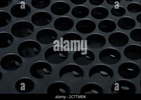 Holes in black matte surface macro close up view Stock Photo