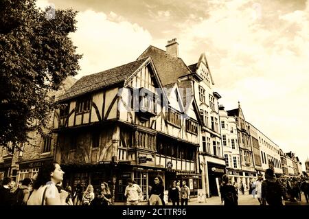 OXFORD, UK - AUGUST 23, 2017: Cornmarket Street (major shopping street and pedestrian area) crowded with tourists and locals. Sepia historic photo Stock Photo