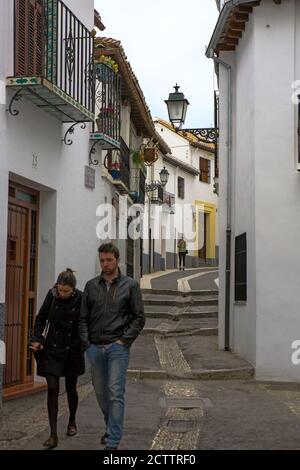 Young couple walk down Calle Agua del Albayzín, El Albaicín, Granada, Andalusia, Spain: a pedestrian street in the old Moorish quarter of Granada Stock Photo