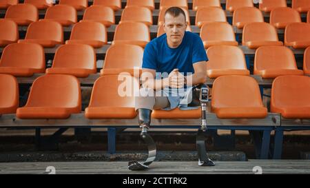 Athletic Disabled Fit Man with Prosthetic Running Blades is Preparing for a Training on an Outdoor Stadium on a Sunny Afternoon. Amputee Runner is Stock Photo