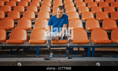 Athletic Disabled Fit Man with Prosthetic Running Blades is Preparing for a Training on an Outdoor Stadium on a Sunny Afternoon. Amputee Runner is Stock Photo