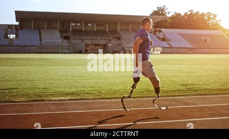 Athletic Disabled Fit Man with Prosthetic Running Blades is Training on an Outdoors Stadium on a Sunny Afternoon. Amputee Runner Jogging on a Stadium Stock Photo