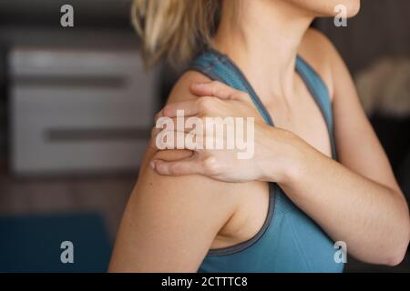 Closeup on fitness woman having pain in shoulder. Pain after home workout Stock Photo